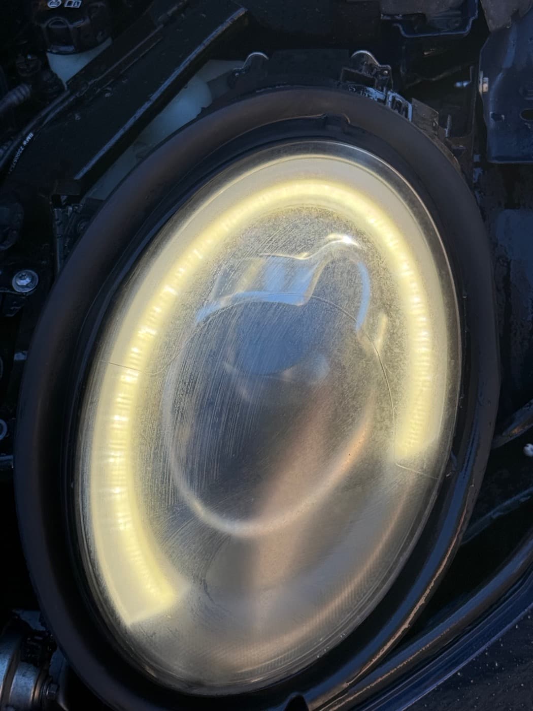 Headlight before restoration showing cloudy lens haze