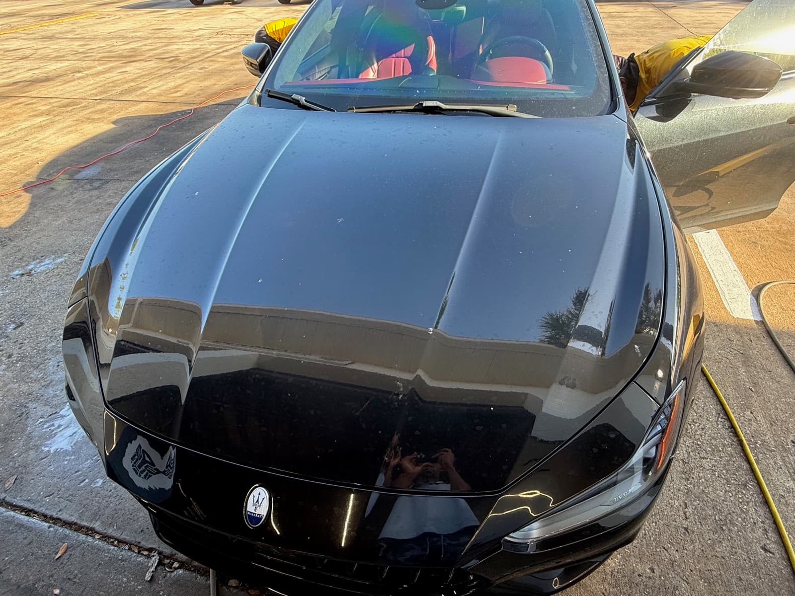 Dark vehicle before paint correction showing less defined gloss